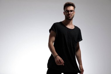 Seksi, akıllı, sıradan bir adam tişörtünü çekip poz veriyor.