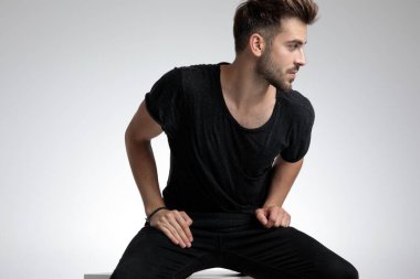 Havalı, sıradan bir adam yana bakıyor ve moda pozu veriyor.