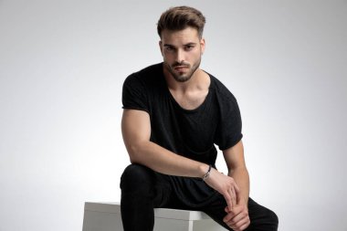 Dramatik havalı adam dizlerinin üstünde moda pozu veriyor.