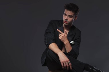 Dramatik genç model parmak uçlarını gösteriyor