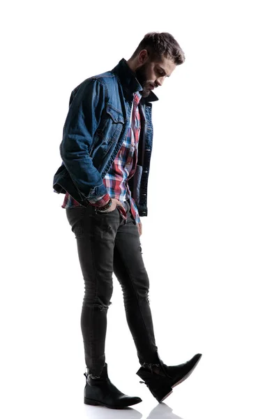 Dramático chico fresco en camisa a cuadros de pie de una manera de moda —  Fotos de Stock