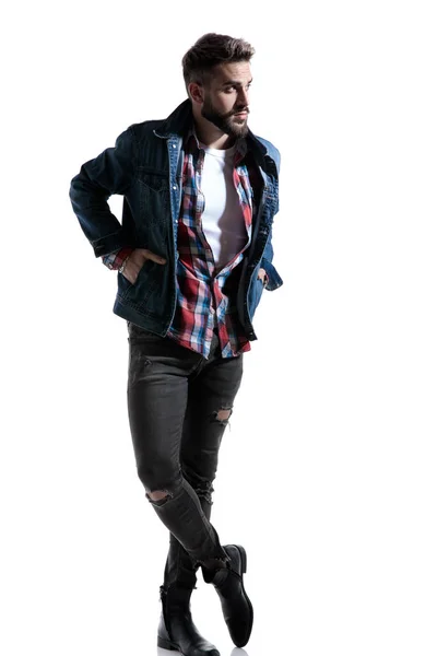 Cool fashion guy in plaid shirt holding hands in pockets — Stock Photo, Image