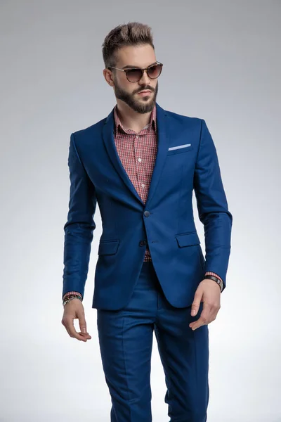 Dramatic cool guy in blue suit wearing sunglasses and posing — Stock Photo, Image