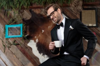 Pozitif model kahve fincanı tutuyor ve gülüyor.