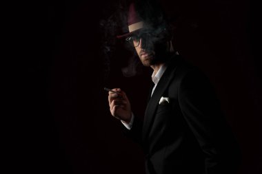 Şapka giyerken sigara içen dramatik manken.