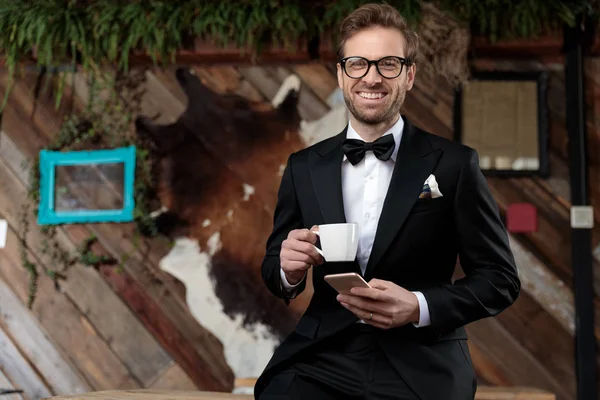 Cheerful groom holding a cup of coffee and smiling — 스톡 사진