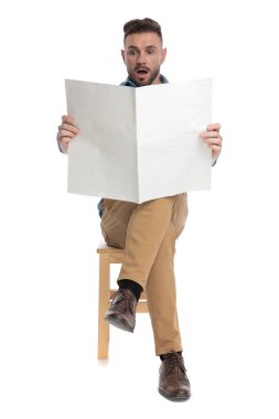 Gazete okuyan sıradan bir genç adam şok oldu.