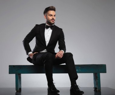 Yakışıklı damat, eli cebinde başka tarafa bakıyor.