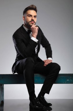 Düşünceli damat, merakla başka tarafa bakıyor. 