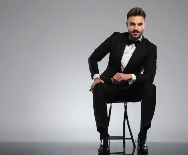 Smokin giyerken gülümseyen yakışıklı genç damat.
