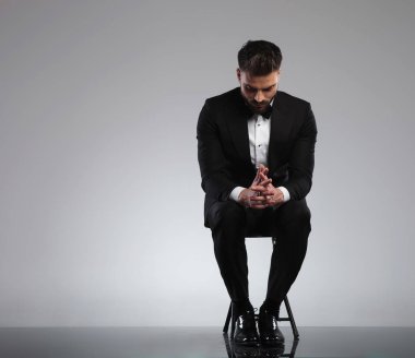 Düşünceli damat otururken dua ediyor ve düşünüyor