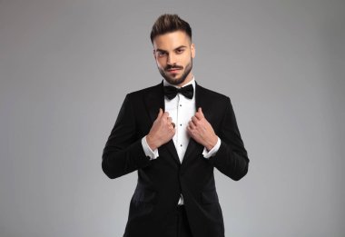 Yakışıklı genç damat ceketini düzeltiyor.