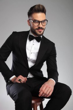 Neşeli damat başka tarafa bakıyor ve gülümsüyor.