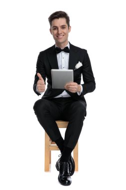 Mutlu genç model sekme tutuyor ve baş parmak işareti yapıyor