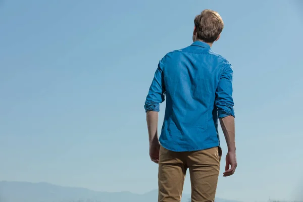 Casual man standing relaxed with hands loose and looking away — ストック写真