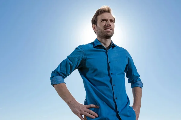 Hombre casual de pie con las manos en la cadera mirando hacia adelante — Foto de Stock