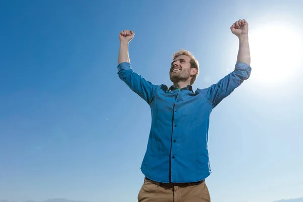 Ung casual man bär blå skjorta firar succes — Stockfoto