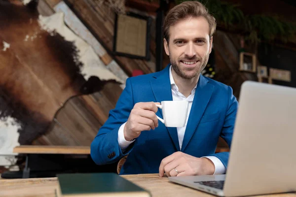 Positieve zakenman glimlachend en met een kopje koffie — Stockfoto