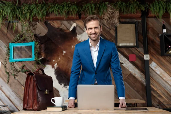 Gelukkig zakenman lachen terwijl staan achter een bureau — Stockfoto