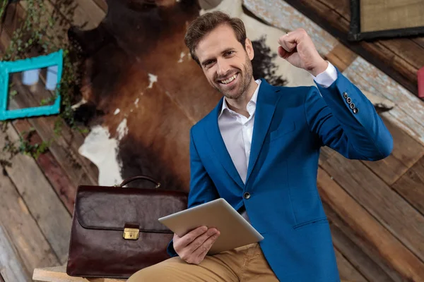 Positieve zakenman vieren en houden van zijn tablet — Stockfoto
