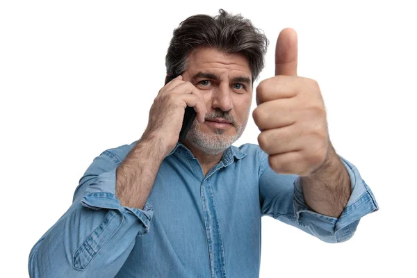 Pozitív alkalmi férfi adja fel a hüvelykujját, beszél telefonon — Stock Fotó