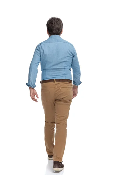 Rear view of a confident casual man walking forward — Stock Photo, Image