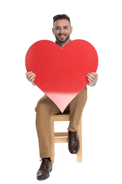 Gelukkig casual man glimlachen en het houden van grote rode hart — Stockfoto