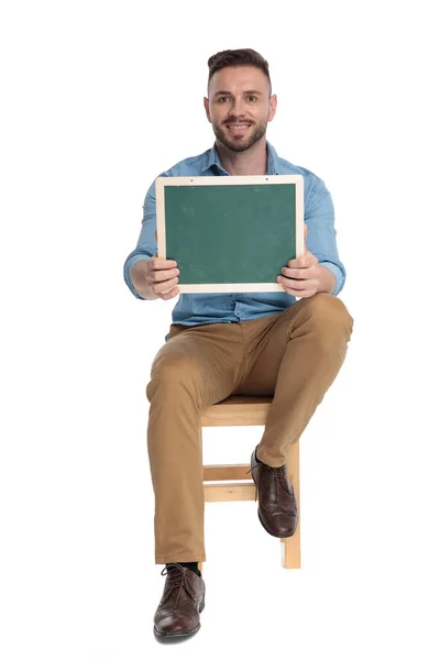 Happy young man holding green board and smiling — 스톡 사진