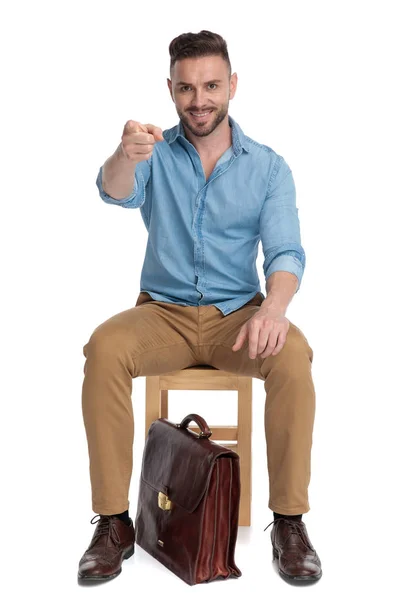 Young casual man smiling and pointing finger — Stock Photo, Image
