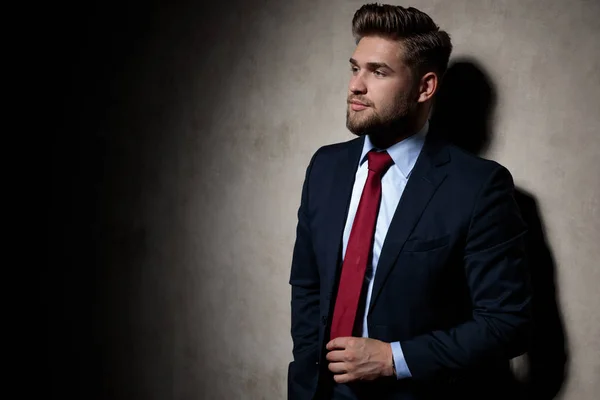 Formell kille som står och tar sin slips på allvar — Stockfoto