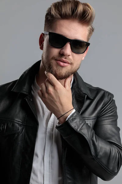 Young fashion model in leather jacket touching beard — Stock Photo, Image