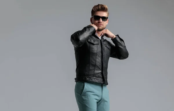 Jovem bonito homem vestindo jaqueta de couro e óculos de sol — Fotografia de Stock