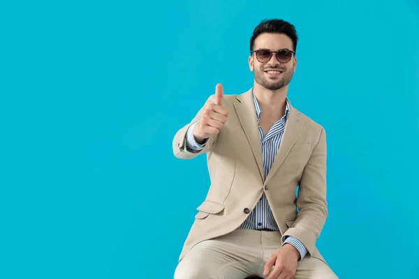 Hombre de moda feliz con gafas de sol y haciendo pulgares hacia arriba signo — Foto de Stock