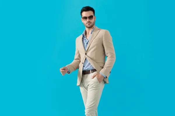 Cool fashion model wearing sunglasses and walking — Stock Photo, Image