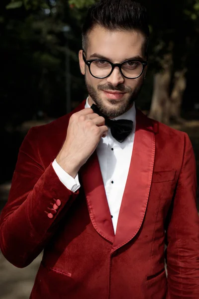 Businessman wearing red tuxedo and eyeglasses fixing bowtie — Stock Photo, Image