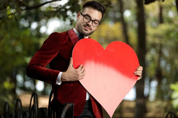 Homme d'affaires chargé d'émotions tenant grand coeur rouge — Photo