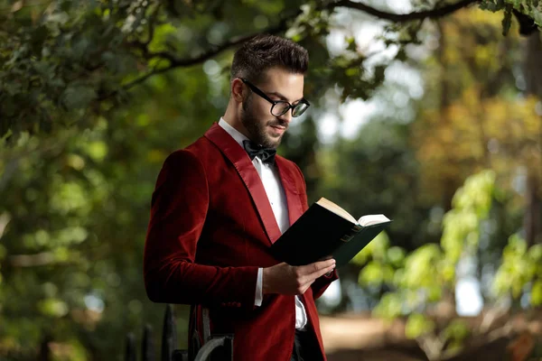 Бизнесмен стоит и читает книги — стоковое фото