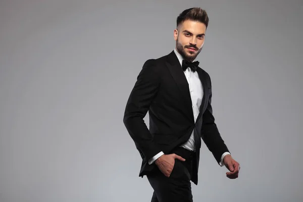 Motivated groom holding his hand in his pocket and smiling — Stock Photo, Image