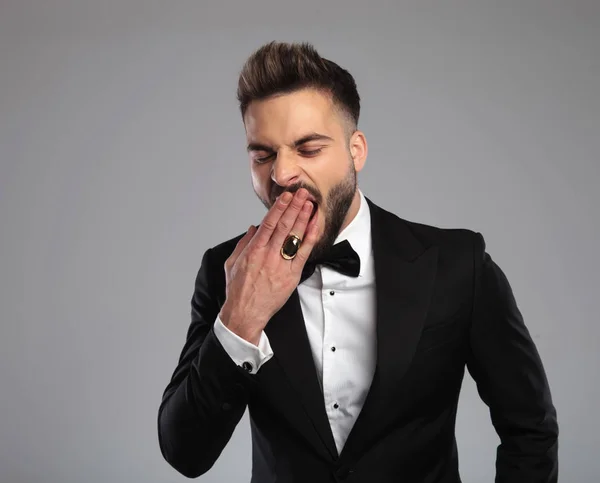 Elegant groom yawning and covering his mouth — Stock Photo, Image