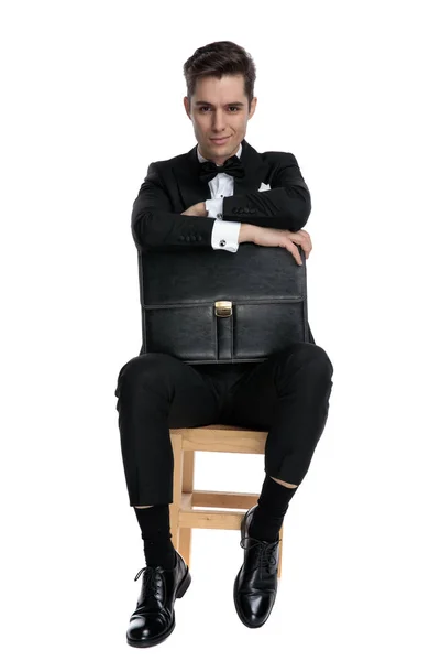 Säker ung man håller resväska och ler — Stockfoto