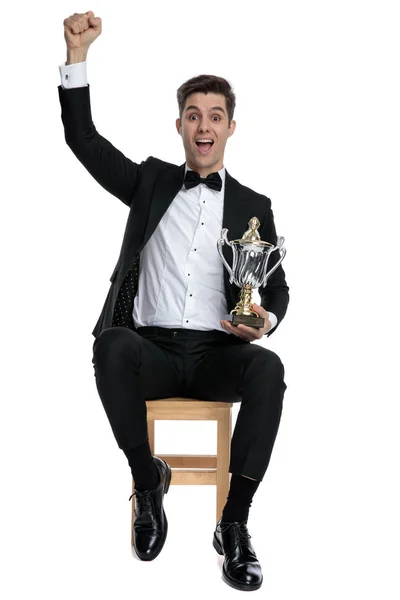 Excited young man celebrating victory and holding trophy — Stock Photo, Image