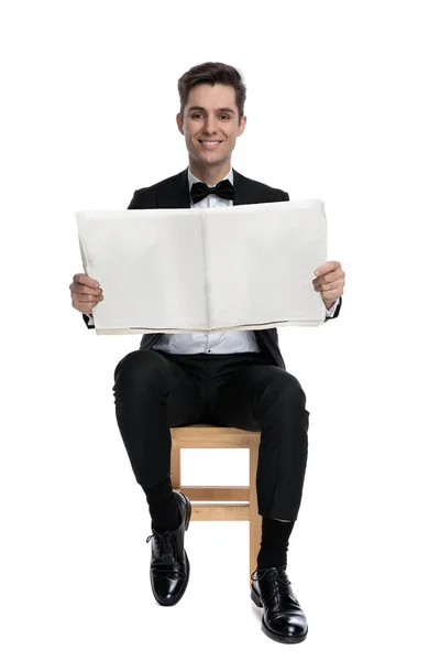 Junger eleganter Mann hält Zeitung und lächelt — Stockfoto