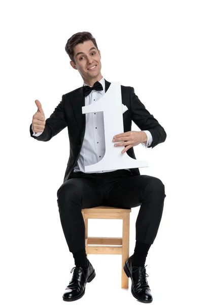 Happy young model holding number one sign — Stock Photo, Image