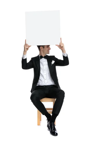 Young elegant man holding empty board above head — 스톡 사진