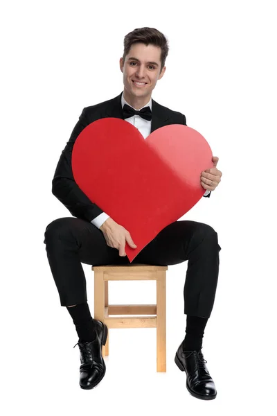 Smiling fashion model holding big red heart — Stock Photo, Image