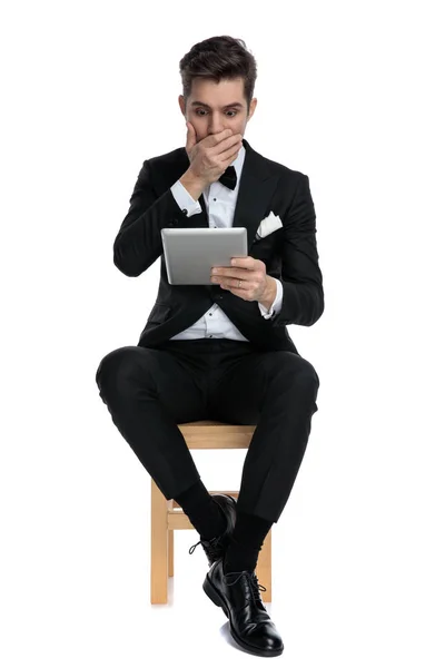 Chockad ung man täcker munnen och håller räkningen — Stockfoto