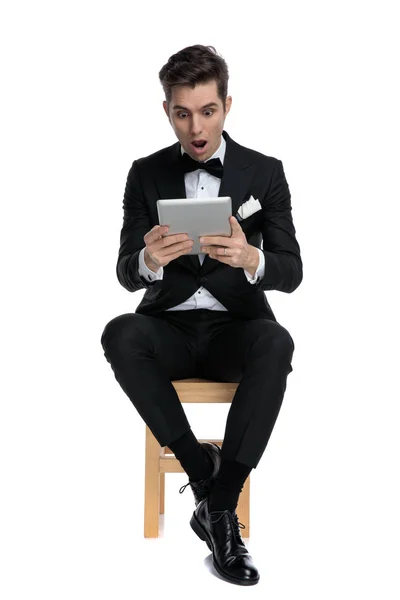 Šokovaný mladý moderní muž drží kartu — Stock fotografie