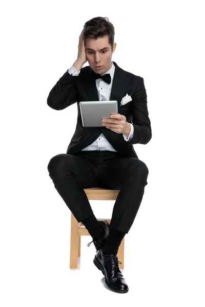 Sorprendido joven elegante hombre celebración lengüeta y tocando la cabeza — Foto de Stock