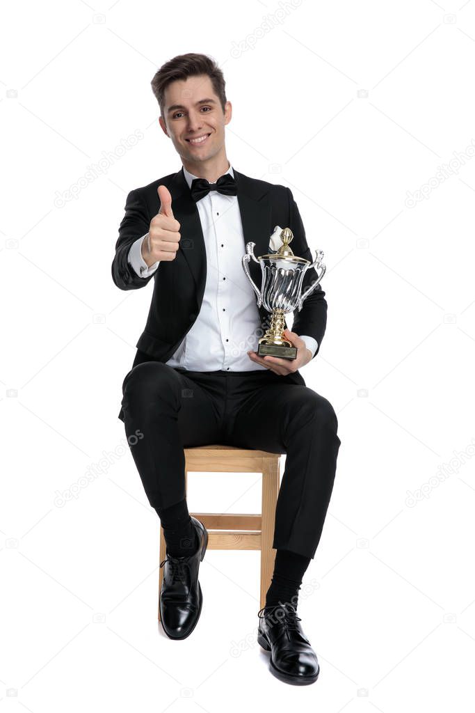young elegant fashion man making thumbs up sign