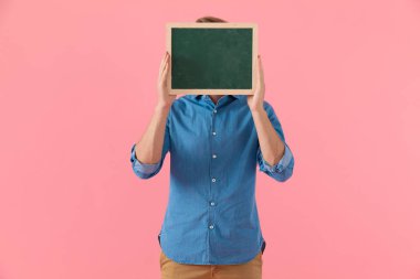 Boş karatahtayla yüzünü kapatan sıradan bir adam.